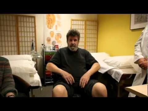 Video thumbnail showing a patient seated in the acupuncture treatment room